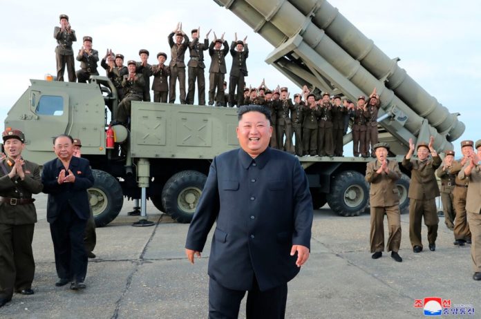 North Korean leader Kim Jong Un, center, smiles after the test firing of an unspecified missile at an undisclosed location in North Korea. North Korea fired two suspected short-range ballistic missiles off its east coast on Saturday in the seventh weapons launch in a month. (Korean Central News Agency/Korea News Service via AP)