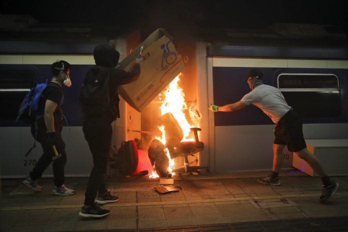 Students burn a train inside the Chinese University MTR station in Hong Kong, Wednesday, Nov. 13, 2019. Protesters in Hong Kong battled police on multiple fronts on Tuesday, from major disruptions during the morning rush hour to a late-night standoff at a prominent university, as the 5-month-old anti-government movement takes an increasingly violent turn. (AP Photo/Kin Cheung)