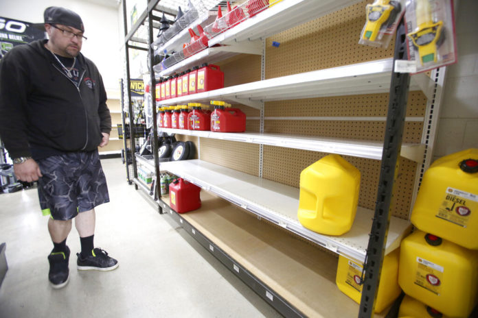Grass Valley's Dionicio Torres looks at the gas can selection before taking the last 5-gallon gas can on the shelves at B&C Ace Home & Garden Center, in Grass Valley, Calif., Tuesday, Nov. 19, 2019, in preparation of Wednesday's planned public safety power shutdown. (Elias Funez/The Union via AP)