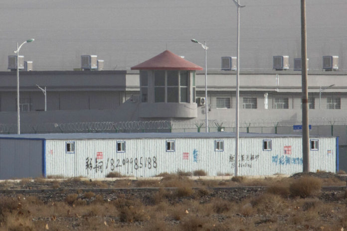 FILE.- In this Monday, Dec. 3, 2018, file photo, a guard tower and barbed wire fences are seen around a facility in the Kunshan Industrial Park in Artux in western China's Xinjiang region. This is one of a growing number of internment camps in the Xinjiang region, where by some estimates 1 million Muslims are detained, forced to give up their language and their religion and subject to political indoctrination. Highly confidential blueprint documents leaked to a consortium of news organizations lay out the Chinese government's deliberate strategy to lock up ethnic minorities to rewire their thoughts and even the language they speak. (AP Photo/File)