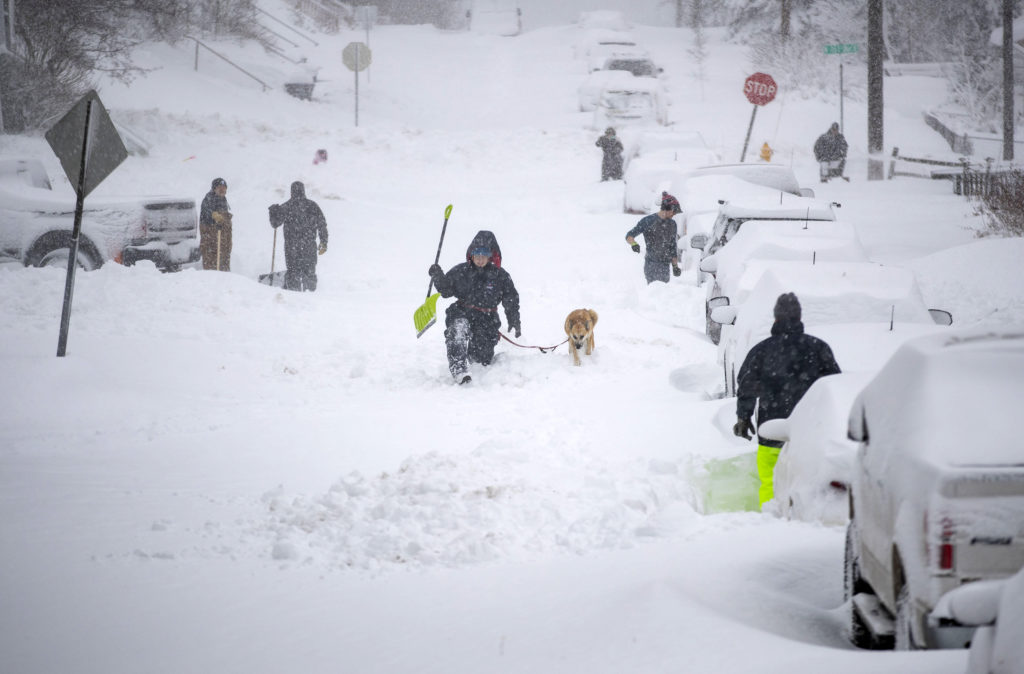 Neighbors work together in an effort to clear out as much snow as possible from E. 8th Street, Sunday, Dec. 1, 2019, in Duluth, Minn. (Alex Kormann/Star Tribune via AP)