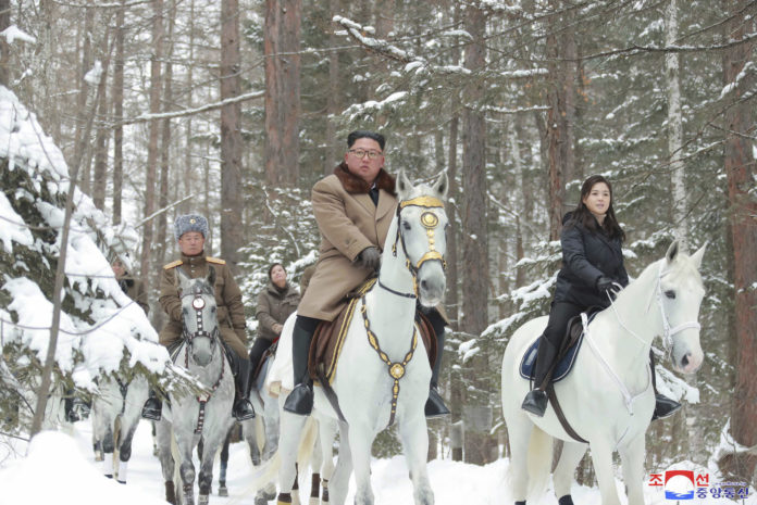 This undated photo provided on Wednesday, Dec. 4, 2019, by the North Korean government shows North Korean leader Kim Jong Un, center, with his wife Ri Sol Ju, right, riding on white horse during his visit to Mount Paektu, North Korea. North Korea says leader Kim has taken a second ride on a white horse to a sacred mountain in less than two months. Independent journalists were not given access to cover the event depicted in this image distributed by the North Korean government. The content of this image is as provided and cannot be independently verified. Korean language watermark on image as provided by source reads: "KCNA" which is the abbreviation for Korean Central News Agency. (Korean Central News Agency/Korea News Service via AP)