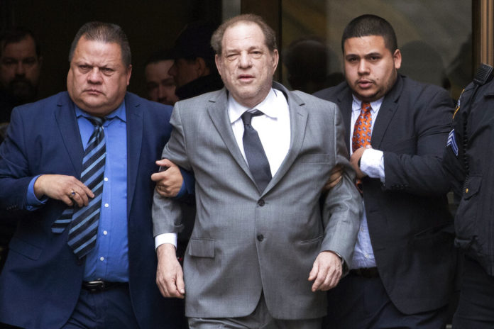 FILE - This Dec. 6, 2019 file photo shows Harvey Weinstein, center, leaving court following a bail hearing in New York. A former model who accused Weinstein last year of sexually abusing her when she was 16 filed a new lawsuit against him Thursday, Dec. 19, saying she didn't want to be included in a proposed global settlement that would split $25 million among various accusers. (AP Photo/Mark Lennihan, File)