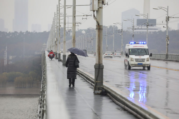 An ambulance drives across a bridge in Wuhan in central China's Hubei province, Saturday, Jan. 25, 2020. The virus-hit Chinese city of Wuhan, already on lockdown, banned most vehicle use downtown and Hong Kong said it would close schools for two weeks as authorities scrambled Saturday to stop the spread of an illness that is known to have infected more than 1,200 people and killed 41, according to officials. (Chinatopix via AP)