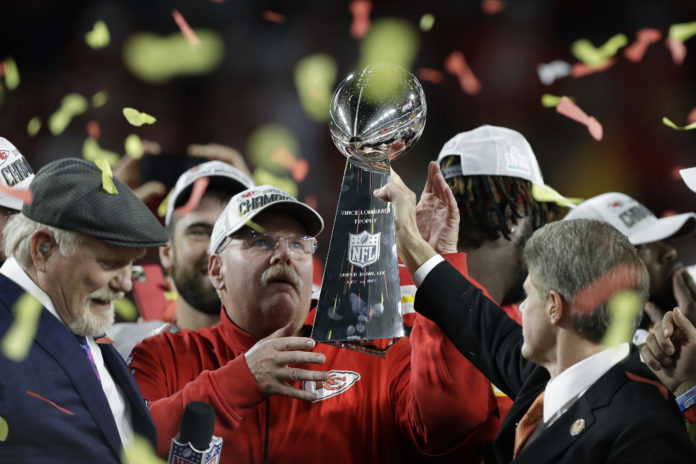 Kansas City Chiefs chairman Clark Hunt, right, hands the trophy to head coach Andy Reid after the chiefs defeated the San Francisco 49ers in the NFL Super Bowl 54 football game Sunday, Feb. 2, 2020, in Miami Gardens, Fla. (AP Photo/Chris O'Meara)