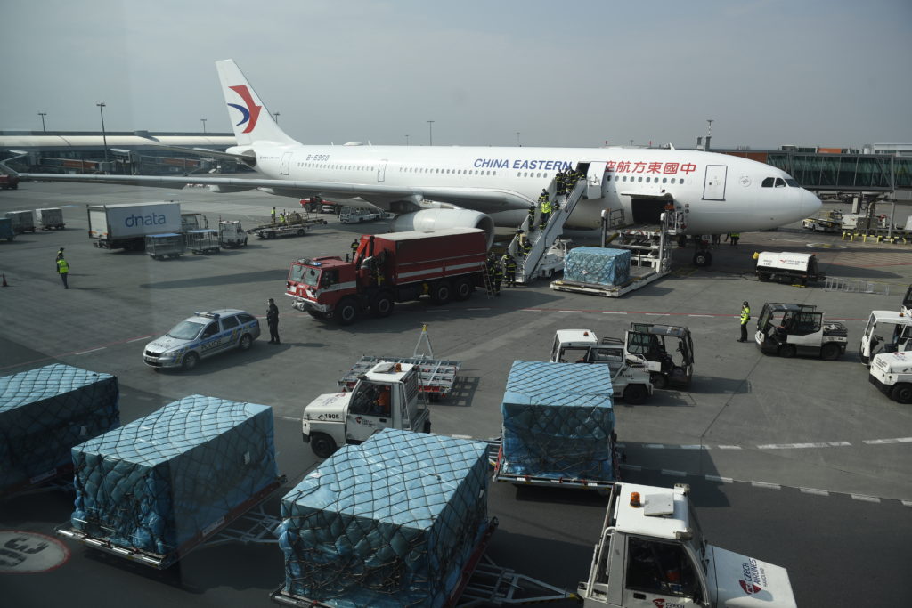 Firefighters unload an airplane after its arrival at the Vaclav Havel Airport in Prague, Friday, March 20, 2020. The airplane brought medical aid and protective materials against coronavirus from China. (Michal Kamaryt/CTK via AP)