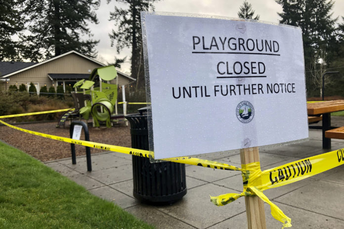 Police caution tape surrounds a playground in Lake Oswego, Ore., on Tuesday, March 24, 2020, the day after Gov. Kate Brown issued a statewide stay-at-home order that closed many businesses, as well as all playgrounds, basketball courts and sport courts. As families across the country and the globe hunker down at home, it's another danger, equally insidious if less immediately obvious, that has advocates deeply concerned: A potential spike in domestic violence, as victims spend day after day trapped at home with their abusers. (AP Photo/Gillian Flaccus)
