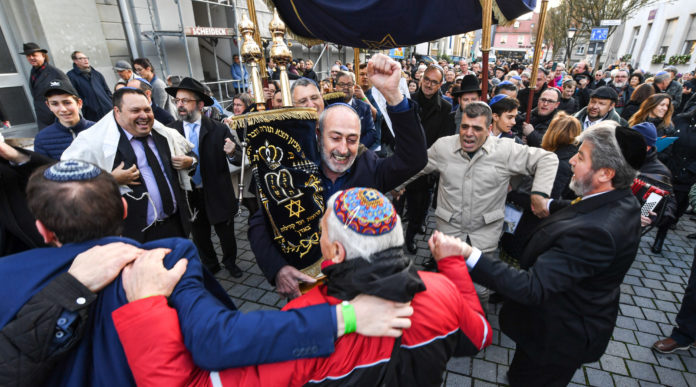dpatop - 10 November 2019, Baden-Wuerttemberg, Konstanz: Hundreds of people of Jewish faith walk and dance with their Torah rolls from the old synagogue to the new one. Photo: Felix Kästle/dpa (Photo by Felix Kästle/picture alliance via Getty Images)