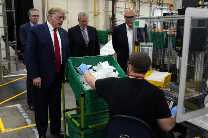 President Donald Trump participates in a tour of a Honeywell International plant that manufactures personal protective equipment, Tuesday, May 5, 2020, in Phoenix, with Tony Stallings, vice president of Integrated Supply Chain at Honeywell, right and White House chief of staff Mark Meadows. (AP Photo/Evan Vucci)