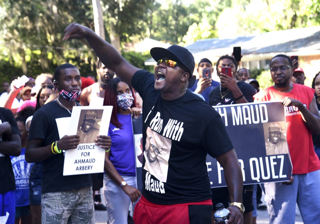 CORRECTS SPELLING OF FIRST NAME TO AHMAUD INSTEAD OF AHMOUD – In this Tuesday, May 5, 2020, photo, Keith Smith speaks to a crowd as they march through a neighborhood in Brunswick, Ga. They were demanding answers regarding the death of Ahmaud Arbery. An outcry over the Feb. 23 shooting of Arbery has intensified after cellphone video that lawyers for Arbery’s family say shows him being shot to death by two white men. (Bobby Haven/The Brunswick News via AP)