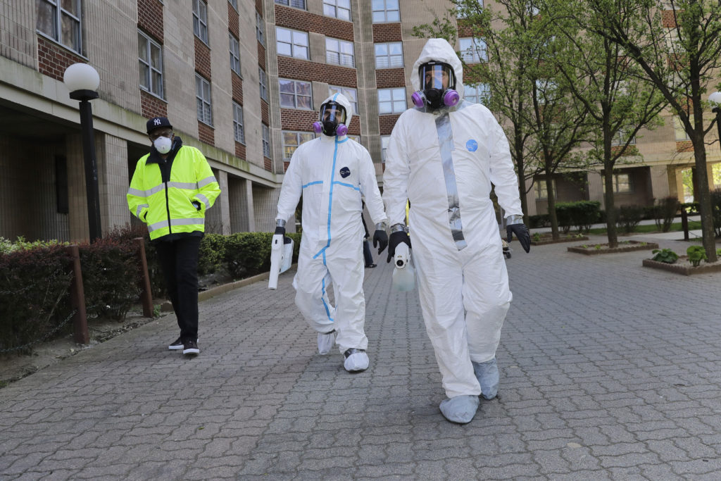 Safety Director Tony Barzelatto, right, Environmental Specialist Anthony Olivieri, center, and Riverbay Corporation General Manager Noel Ellison leave a just disinfected building in Co-op City in the Bronx borough of New York, Wednesday, May 13, 2020. Regular cleanings occur throughout the common areas of the buildings while the heavy disinfecting occurs in response to specific incidents, in this case reports of two coronavirus cases on the same floor. Within the Bronx, almost no place has been hit as hard as Co-op City. (AP Photo/Seth Wenig)