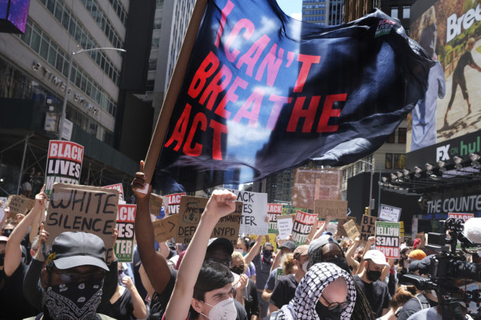 Protesters rally near the edge of Times Square in New York, Sunday, June 7, 2020. New York City lifted the curfew spurred by protests against police brutality ahead of schedule Sunday after a peaceful night, free of the clashes or ransacking of stores that rocked the city days earlier. (AP Photo/Seth Wenig)
