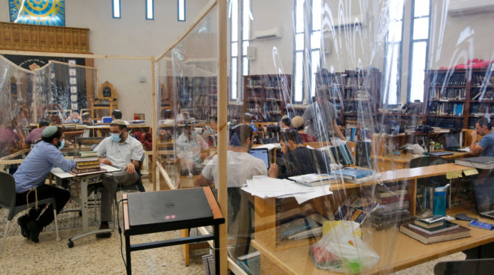 Israeli Yeshiva (Jewish educational institution for studies of traditional religious texts) students are picture at their learning centre separated by plastic barriers to insure that social distancing measures imposed by Israeli authorities meant to curb the spread of the novel coronavirus are being respected, in Tel Aviv on July 7, 2020. (Photo by GIL COHEN-MAGEN/AFP via Getty Images)