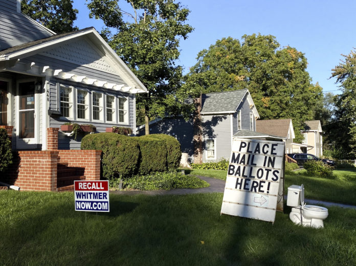 A political display is set up in the lawn of a home in Mason, Mich., seen Friday, Sept. 18, 2020. Barb Byrum, the Democratic clerk of Ingham County, filed a complaint with police over the display, saying it could mislead people who aren’t familiar with how mail-in voting works. (Matthew Dae Smith/Lansing State Journal via AP)