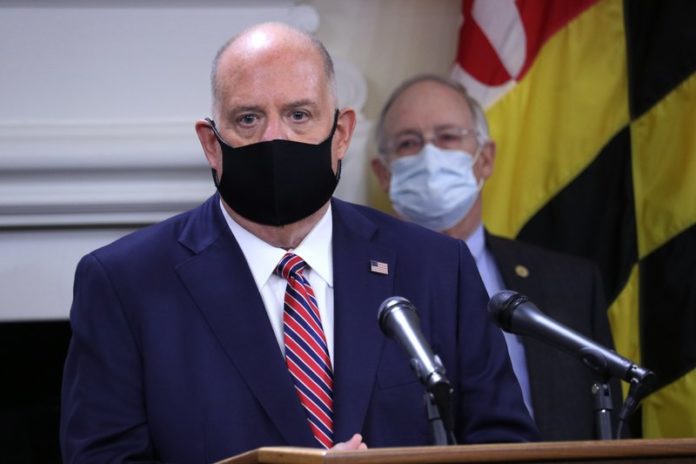 Maryland Gov. Larry Hogan urges people to wear masks to prevent the spread of the coronavirus as the nation experiences rising numbers of cases, while speaking at a news conference Thursday, Nov. 5, 2020, in Annapolis, Md. Hogan said masks are the best way to fight the virus to keep people safe and keep Maryland open for business. Maryland Health Secretary Robert Neall stands behind Hogan. (AP Photo/Brian Witte)
