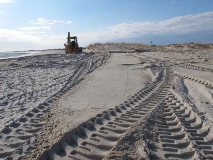 Freshly smoothed sand covers the carcass of a 15-ton humpback whale that was buried in the sand in Barnegat Light, N.J. on Monday, Dec. 28, 2020. The whale had washed ashore three days earlier. (AP Photo/Wayne Parry)