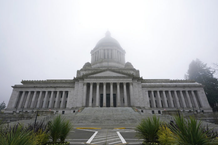 FILE - In this Jan. 7, 2021, file photo, the Legislative Building is shown partially shrouded in fog at the Capitol in Olympia, Wash. Washington state's richest residents, including Bill Gates and Jeff Bezos, would pay a wealth tax on certain financial assets worth more than $1 billion under a proposed bill whose sponsor says she is seeking a fair and equitable tax code. Under the bill, starting Jan. 1, 2022, for taxes due in 2023, a 1% tax would be levied not on income, but on "extraordinary" assets ranging from cash, publicly traded options, futures contracts, and stocks and bonds. (AP Photo/Ted S. Warren, File)