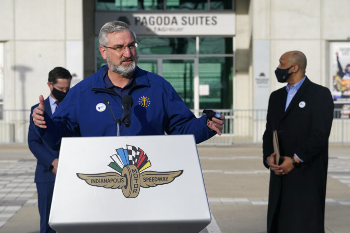 Indiana Gov. Eric Holcomb speaks after receiving his Johnson & Johnson COVID-19 vaccine during the state's first mass vaccination clinic at the Indianapolis Motor Speedway, Friday, March 5, 2021, in Indianapolis. The state health department said nearly 17,000 people had filled up four days of appointments for the speedway clinic being held Friday through Monday. (AP Photo/Darron Cummings)